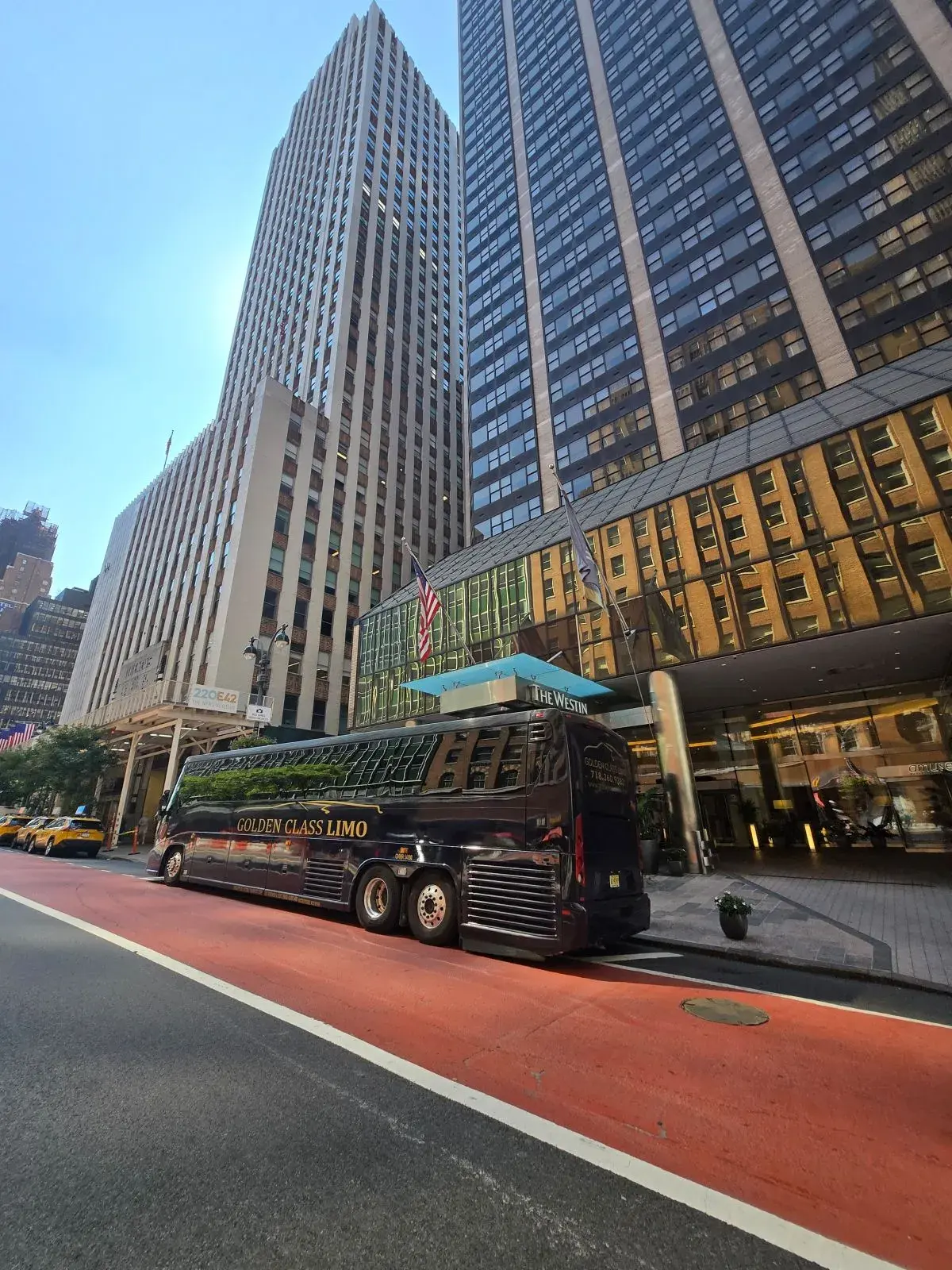 Black Golden Class Limo motor coach with gold lettering outside a Midtown Manhattan hotel