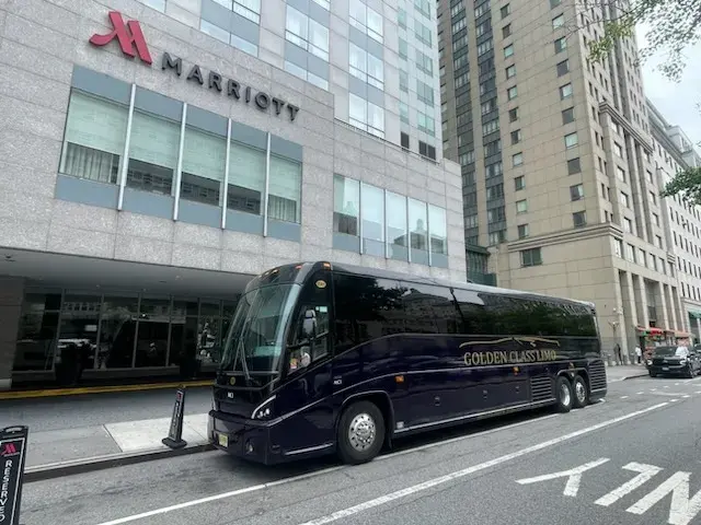Black Golden Class Limo motor coach with gold lettering outside a Manhattan Marriott