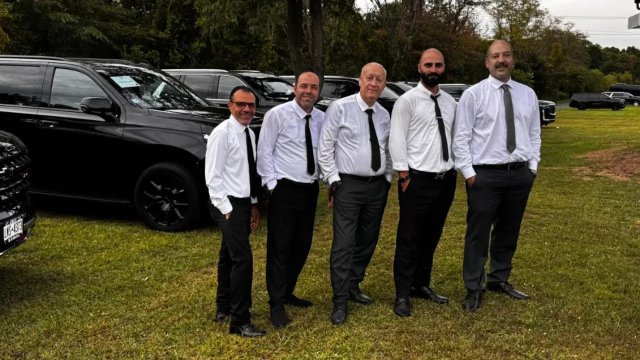 Golden Class Limo chauffeurs in suits beside a line of black Cadillac Escalades